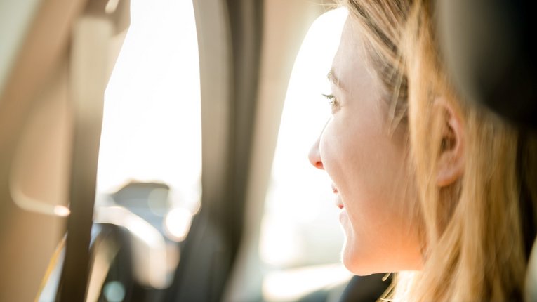 Junge Frau lächelnd im Auto