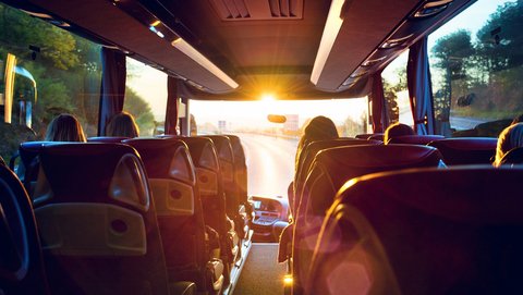 In die Sitzreihen eines Reisebus scheint die Sonne
