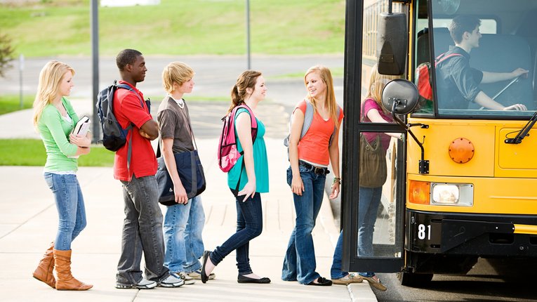 Kinder steigen in gelben Schulbus