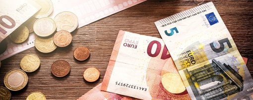 Table with Euro notes and coins and calculator