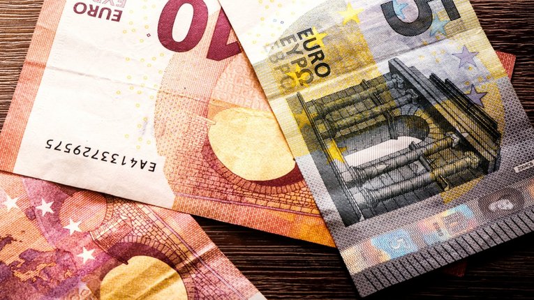 Tisch mit Euro Scheinen und Münzen und Taschenrechner