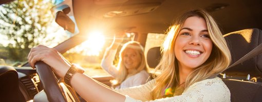 Zwei Frauen glücklich im Auto bei Sonnenschein