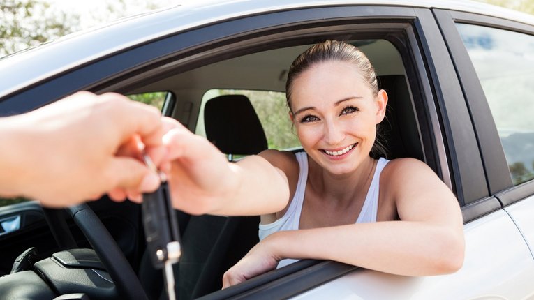 Mädchen greift aus Autofenster nach Autoschlüssel
