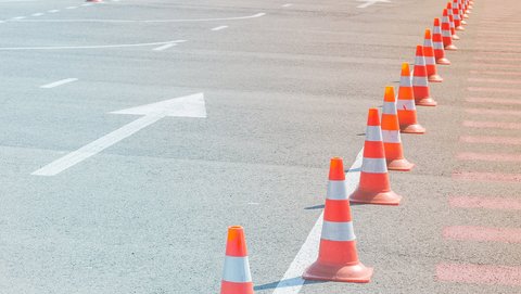 Orange Pylone auf Straße mit Pfeil