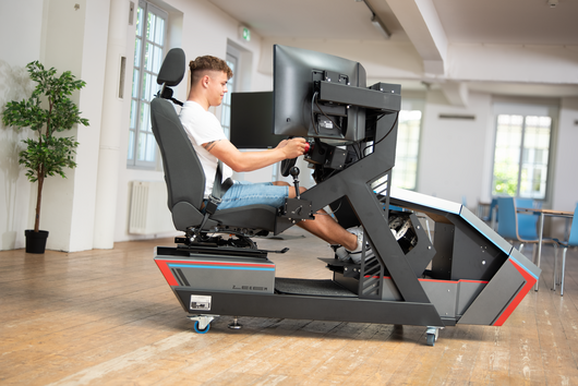 Junger Mann fährt im Fahrsimulator