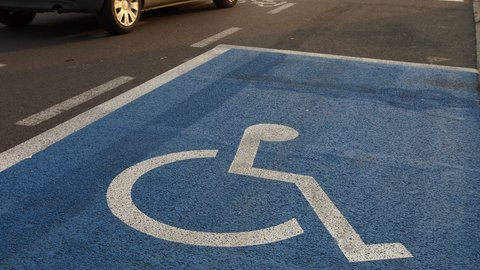 Blau gekennzeichneter Behindertenparkplatz auf der Straße