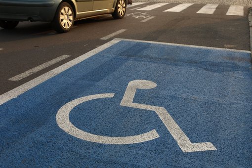 Blau gekennzeichneter Behindertenparkplatz auf der Straße