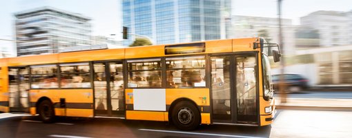 Gelber Linienbus fährt durch Stadt