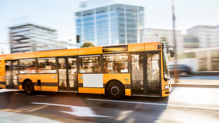 Gelber Linienbus fährt durch Stadt