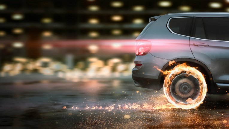 Ein Auto macht eine scharfe Vollbremsung so das die Reifen glühen.