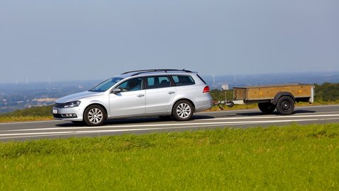 Auto mit Anhänger fährt auf Landstraße