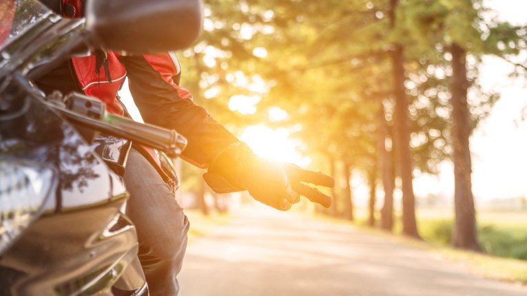 Motorradfahrer zeigt Peace gegen Sonne